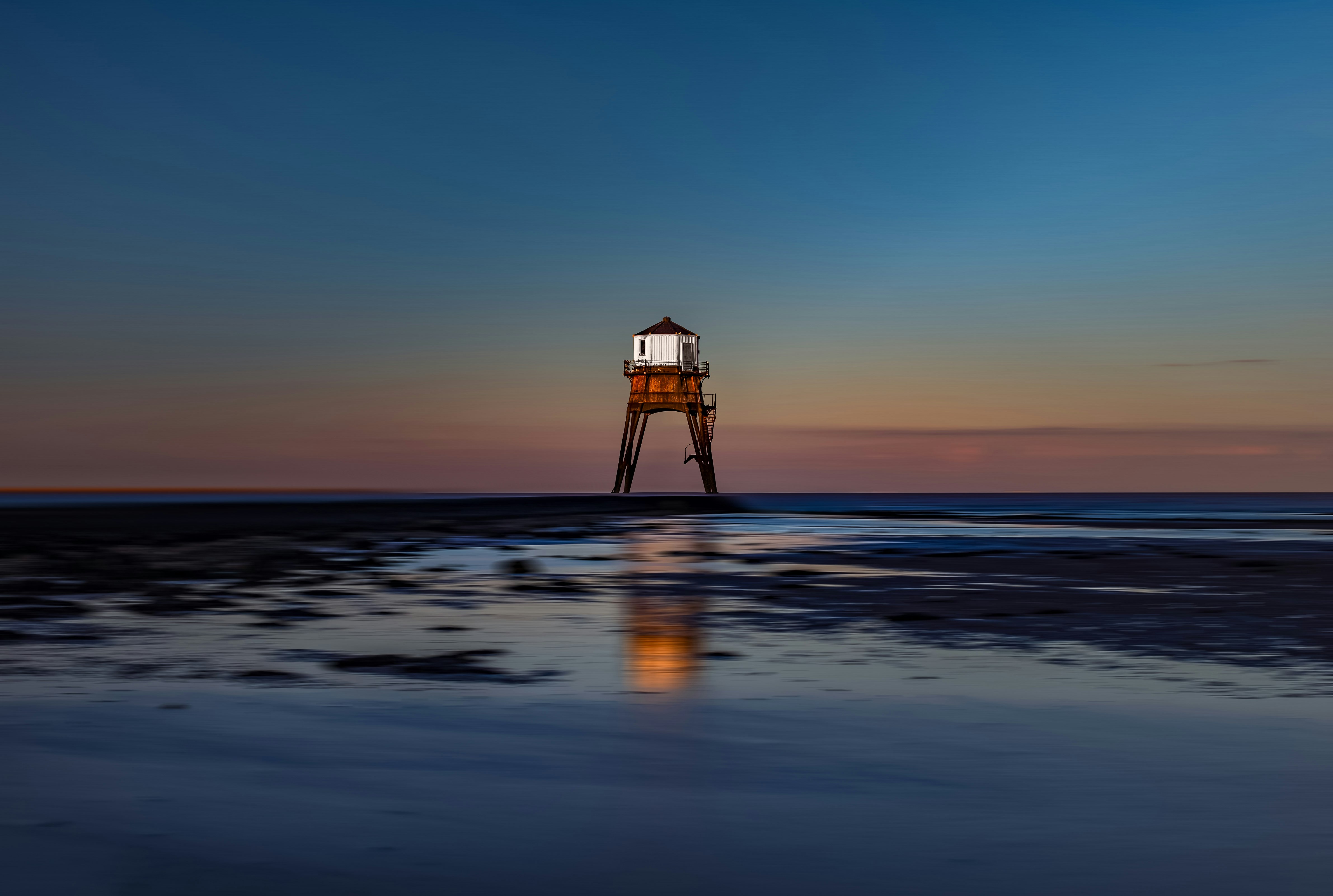 white lifeguard house on beach during sunset